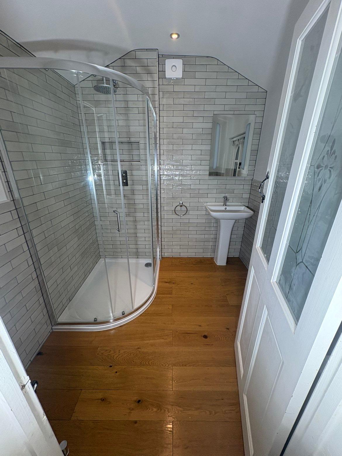 Shower room after renovation - subway tiles and oak flooring